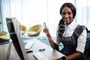 Business woman holding credit card and using computer