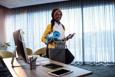 Businesswoman with yoga mat