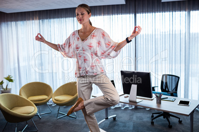 Businesswoman doing yoga on a table