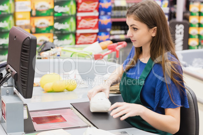 Woman cashier beeping an item