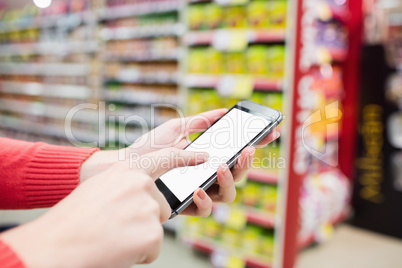 Focus on foreground of woman touching her mobile phone