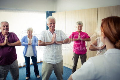 Group of seniors doing exercises with nurse