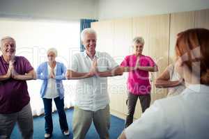 Group of seniors doing exercises with nurse