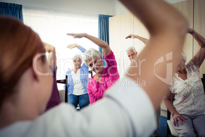 Group of seniors doing exercises with nurse