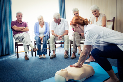 Nurse teaching first aid to a group of seniors