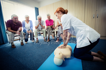 Nurse teaching first aid to a group of seniors