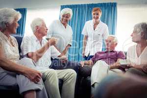 Group of seniors interacting with nurse