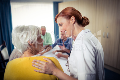 Pensioners playing cards with nurse