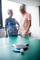 Couple of seniors interacting behind a ping pong table