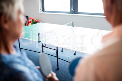 Two seniors front of a ping pong table