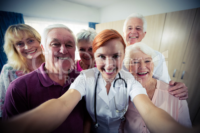 Group of seniors with nurse doing a selfie