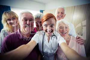 Group of seniors with nurse doing a selfie