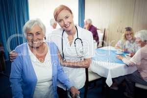 Portrait of a nurse assisting a senior using a walker