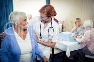 Nurse assisting a senior using a walker