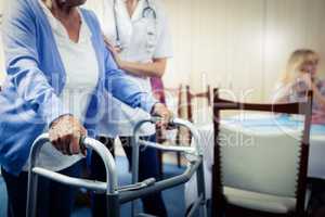 Nurse assisting a senior using a walker