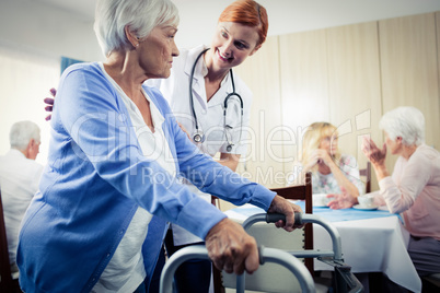 Nurse assisting a senior using a walker