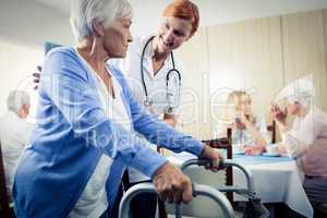 Nurse assisting a senior using a walker