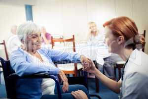 Nurse interacting with a senior woman in wheelchair