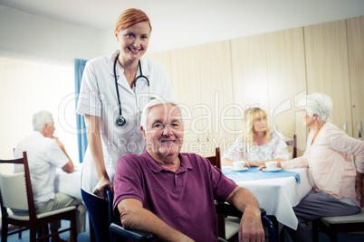 Portrait of a nurse with senior man in wheelchair