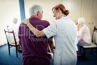 Nurse assisting a senior using a walker