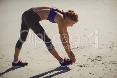 Fit woman warming up on beach