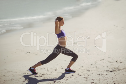 Fit woman warming up on beach