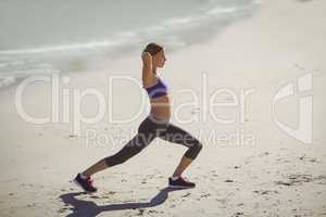 Fit woman warming up on beach