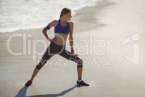 Fit woman warming up on beach