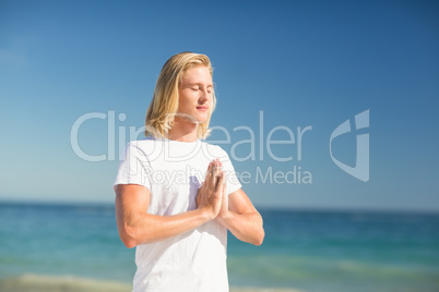 Man performing yoga on beach