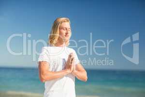 Man performing yoga on beach