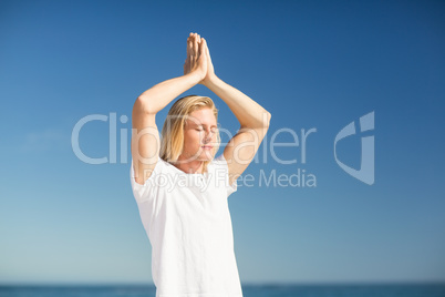 Man performing yoga on beach