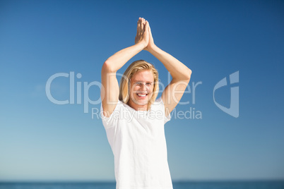 Man performing yoga on beach