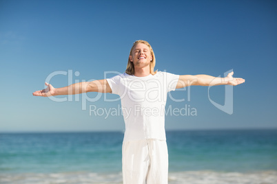 Happy man standing with arms stretched