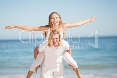 Man giving piggy back ride to woman