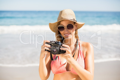 Attractive woman in bikini checking photographs