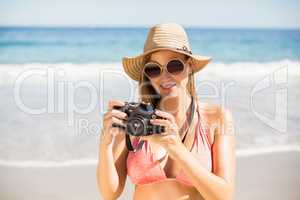 Attractive woman in bikini checking photographs