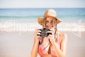 Attractive woman in bikini taking photographs