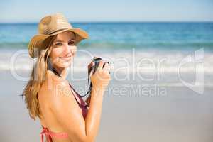 Attractive woman in bikini taking photographs
