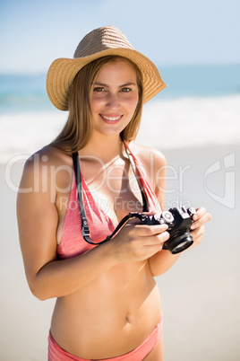 Attractive woman in bikini checking photographs