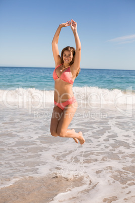 Young woman jumping on beach