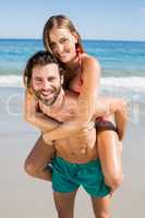Man giving piggy back ride to woman