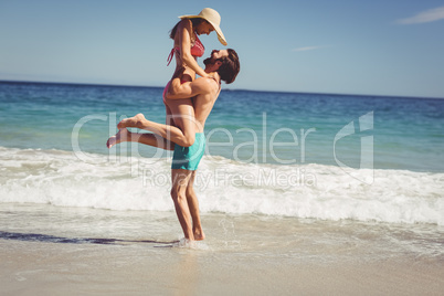 Man lifting woman at beach