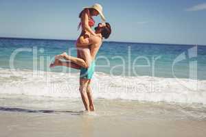 Man lifting woman at beach
