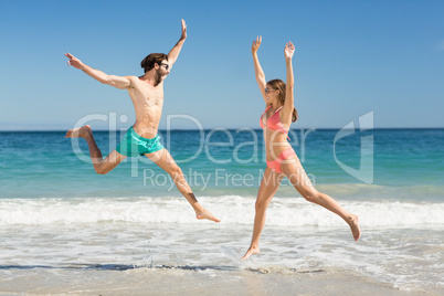 Couple jumping on beach