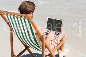 Man sitting on armchair at beach