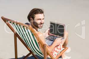 Man sitting on armchair at beach