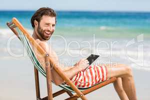 Man sitting on armchair at beach