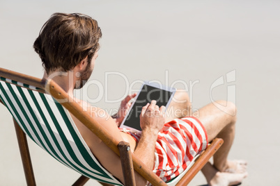 Man sitting on armchair at beach