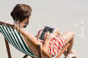 Man sitting on armchair at beach