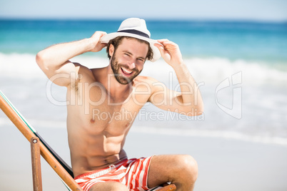 Man sitting on armchair at beach